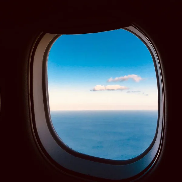 Gros plan de beaux nuages à travers la fenêtre de l'avion pendant la journée — Photo