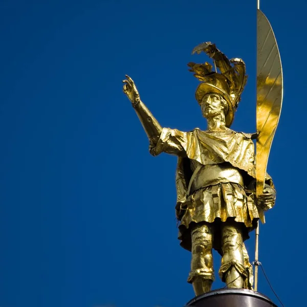Közelkép egy arany szoborról, tiszta égbolttal a háttérben. — Stock Fotó
