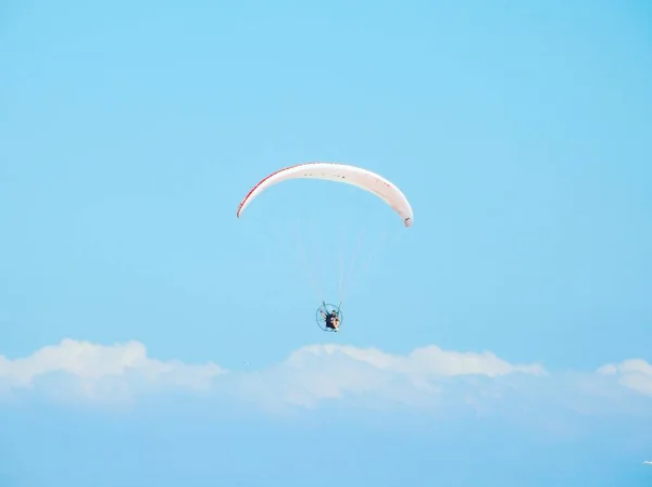 아름다운 구름낀 하늘 아래서 낙하산을 타고 내려가는 사람을 낮은 각도로 찍은 사진 — 스톡 사진