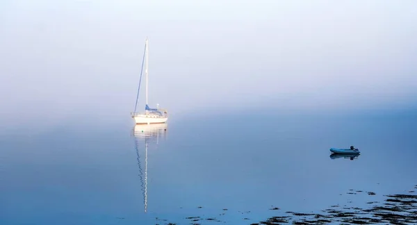 Krásný záběr lodi, jak se vynořuje z mlhy na vodě v Maine, USA — Stock fotografie