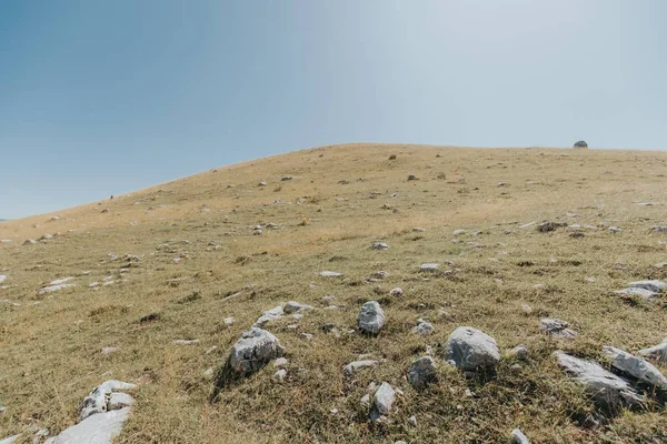Vertikale Aufnahme von Bergen und Hügeln mit vielen Felsen unter dem schönen blauen Himmel — Stockfoto