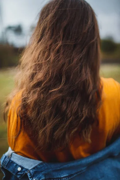 Tiro de close-up seletivo de uma jovem fêmea com cabelo longo e uma jaqueta jean — Fotografia de Stock