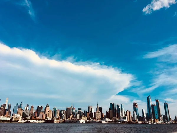 Ampia foto del bellissimo mare e del grattacielo sulla riva sotto il cielo nuvoloso — Foto Stock