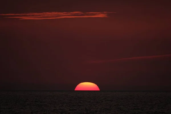 Schöne Aufnahme der untergehenden Sonne in einem roten Himmel — Stockfoto