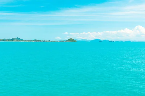 Belo tiro do mar com a costa na distância abaixo de um céu azul — Fotografia de Stock