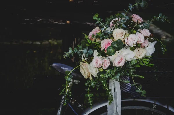 Primer plano selectivo de un ramo de flores de rosas y hojas verdes en una cesta de bicicletas — Foto de Stock