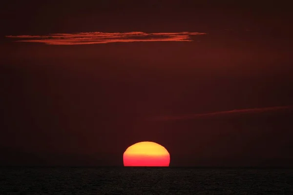 Schöne Aufnahme der untergehenden Sonne in einem roten Himmel — Stockfoto