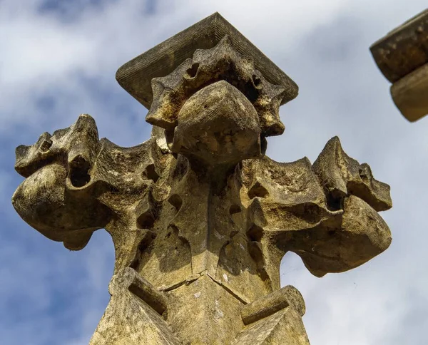 Plan à angle bas d'une sculpture en croix de pierre sous le beau ciel bleu — Photo