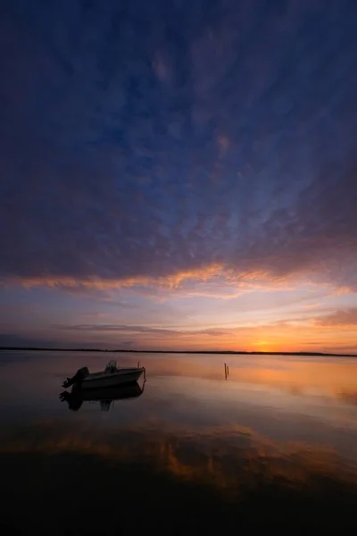 Vertikale Aufnahme eines Bootes auf dem Wasser unter bewölktem Himmel — Stockfoto