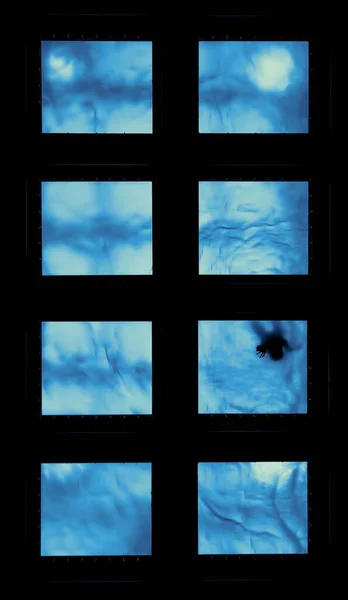 Vertikale Aufnahme abstrakter, wässriger Fenster mit einer gruseligen Silhouette einer Person, die in einem davon zu sehen ist — Stockfoto