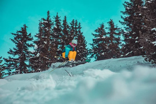 Horizontale opname van een persoon in een skiuitrusting die een gevaarlijke sprong op een piste maakt — Stockfoto