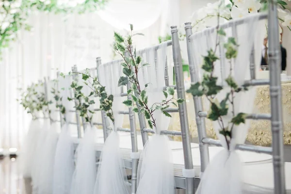 Shallow focused shot of beautiful silver chairs decorated for a wedding near a wedding table — Stock Photo, Image