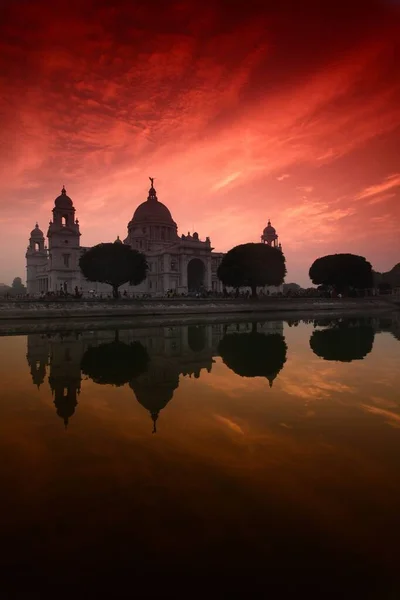 Vertikal bild av Victoria Memorial i Calcutta, Indien speglas i vattnet under den färgglada himlen — Stockfoto