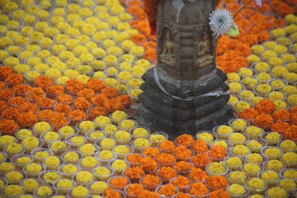 Foto horizontal de flores naranjas y amarillas frente a un buda en Bodhgaya en la India — Foto de Stock
