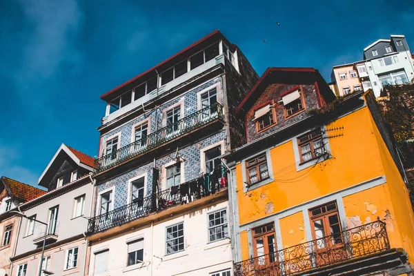 Foto de ángulo bajo de antiguas casas hermosas de diferentes colores con balcones durante el día —  Fotos de Stock