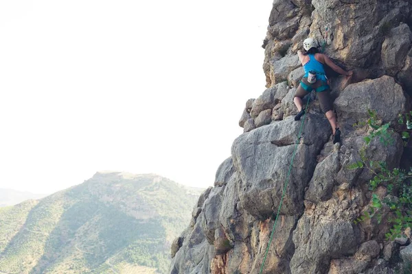 昼間の岩山を登る女性の水平なショット — ストック写真