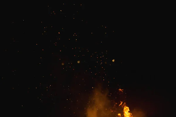 Low angle shot of fire flames with the background of the dark sky during night time — Stock Photo, Image