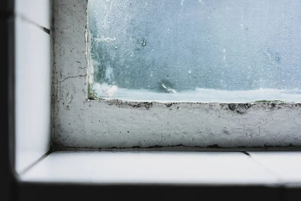 Primer plano de un alféizar de ventana salvaje con una ventana vieja y el vidrio cubierto de glaseado —  Fotos de Stock