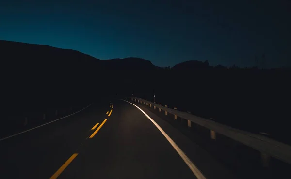 Grande tiro de uma estrada vazia à noite sob o céu escuro — Fotografia de Stock
