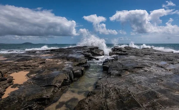 在蓝色的天空下，大海边岩石中间的美丽的水声 — 图库照片