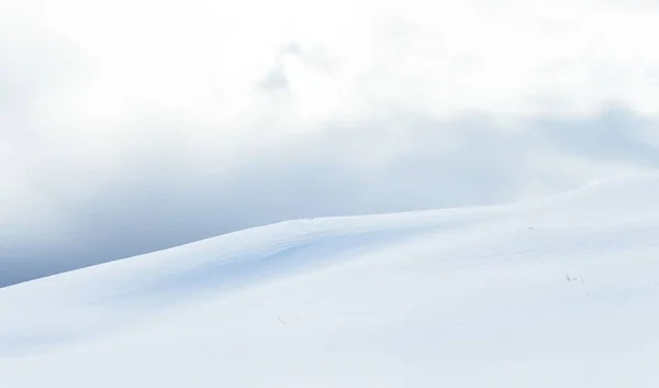 Amplio plano de una zona nevada bajo las hermosas nubes blancas en invierno — Foto de Stock