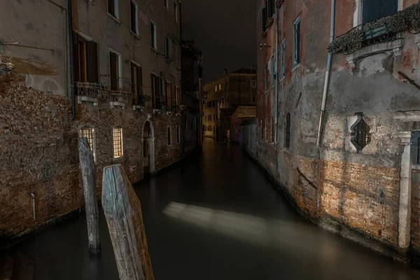 Imagen horizontal de un canal entre antiguos edificios de apartamentos en Venecia, Italia por la noche — Foto de Stock