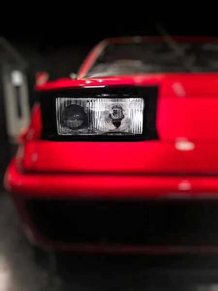 Tiro vertical de um carro vermelho luz com um fundo borrado - ótimo para um papel de parede legal — Fotografia de Stock