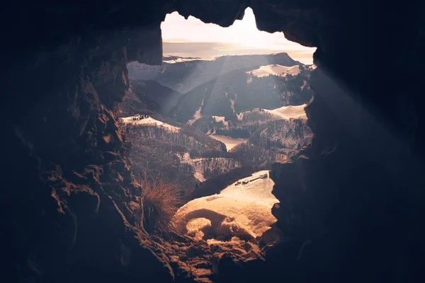 Majestuoso Disparo Través Una Entrada Caverna Montañas Nevadas Cubiertas Bosques —  Fotos de Stock