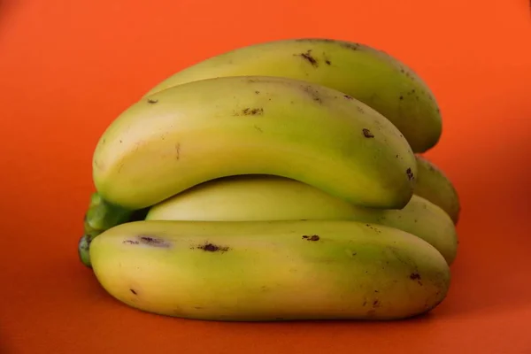Primer plano de saba bananas sobre una superficie naranja — Foto de Stock