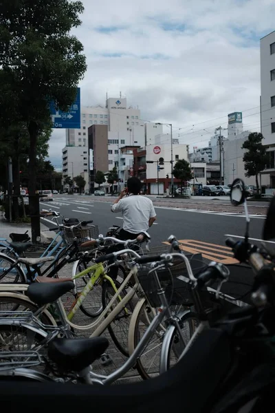 男人白天在人行道上经过很多自行车 — 图库照片