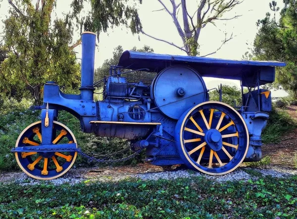 Veículo azul com um motor a vapor perto de árvores com um céu brilhante no fundo em Trragones — Fotografia de Stock