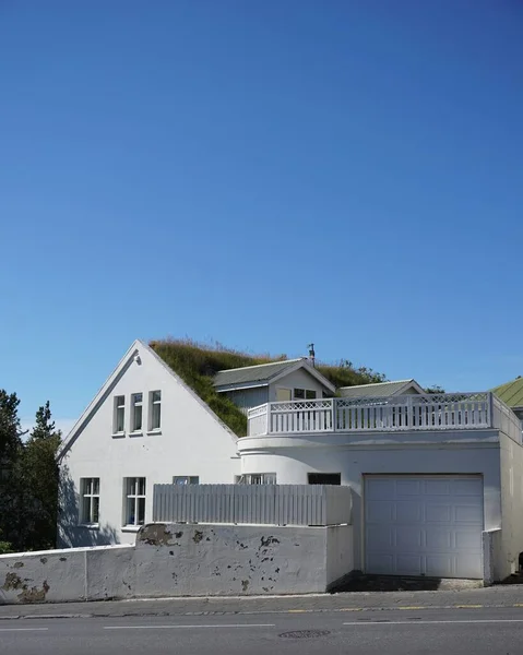 Biały dom w pobliżu drogi z jasnym niebieskim niebem w tle w ciągu dnia — Zdjęcie stockowe