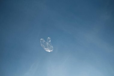 Horizontal shot of a plastic bag flying in the sky during daytime clipart