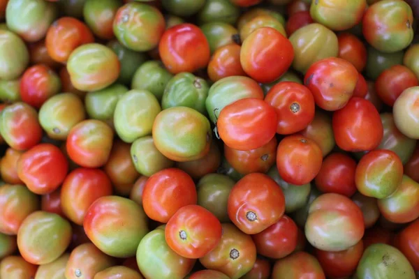Primer plano de una gran cantidad de tomates rojos y verdes en el mercado — Foto de Stock