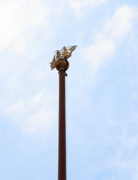 Alacsony szögű lövés egy oszlop egy hajó szimbólum a tetején áll a tiszta világoskék ég alatt — Stock Fotó