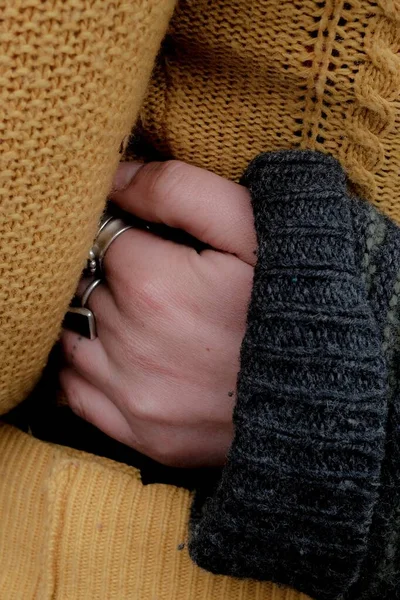 Foto vertical de una hembra con un sudor y su mano con hermosos anillos de plata. — Foto de Stock
