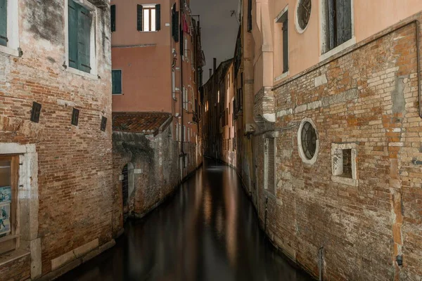 Poziome ujęcie kanału między starymi budynkami w Wenecji, Włochy w nocy — Zdjęcie stockowe