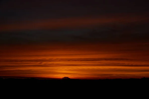 Vista deslumbrante do céu com camadas laranja e amarela durante a noite — Fotografia de Stock