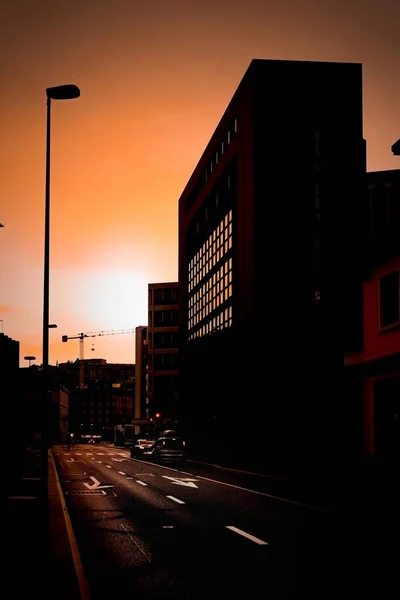 Vertical silhouette of a city with buildings and transportation during golden hour — Stock Photo, Image