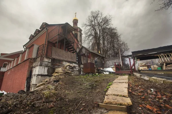 Weitwinkelaufnahme einer von Bäumen umgebenen roten Kirche unter wolkenverhangenem Himmel in Moskau — Stockfoto