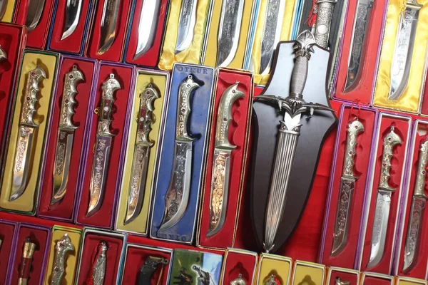 Close-up tiro de um monte de facas com belos desenhos esculpidos em caixas coloridas — Fotografia de Stock