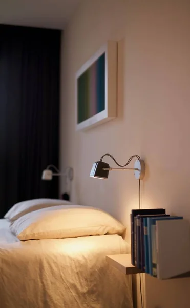 Κάθετη εσωτερική φωτογραφία ενός υπνοδωματίου με φωτισμένο τοίχο εκτός από το κρεβάτι με θολή φόντο — Φωτογραφία Αρχείου