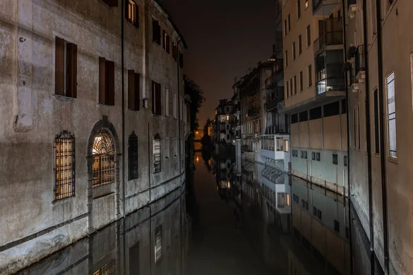 イタリアのパドヴァで夜のアパートの間の運河の水平ショット — ストック写真