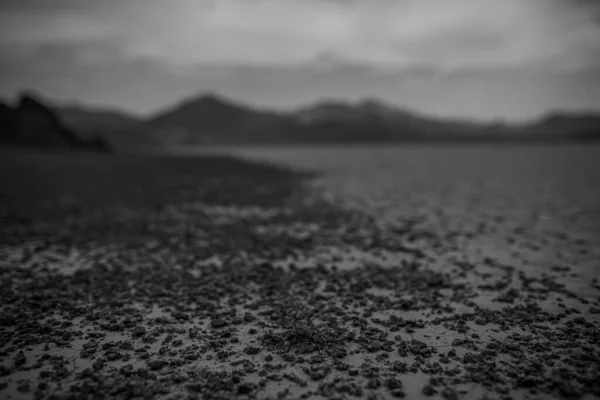 Greyscale πυροβολισμό της Κοιλάδας του Θανάτου καλύπτονται με λάσπη που περιβάλλεται από όμορφα βουνά στην Usa — Φωτογραφία Αρχείου