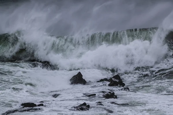 Erős hullám jön és fröcsköl a kövekre a 'Cribber' hullámban, Newquay, Cornwall, Uk — Stock Fotó