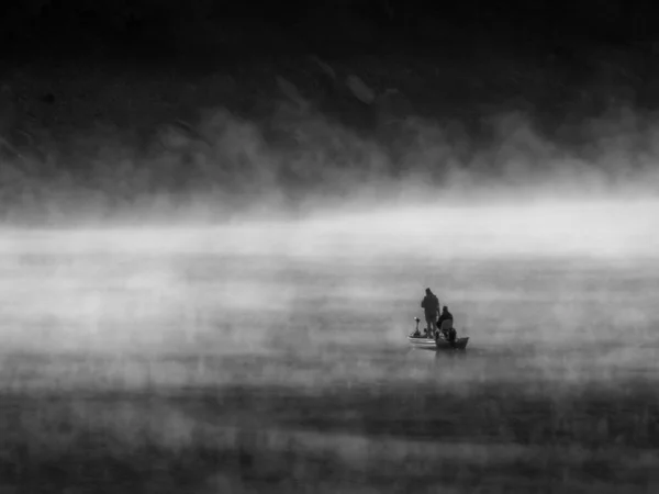 Bella foto di persone sulla barca su un mare vuoto circondato da nebbia — Foto Stock