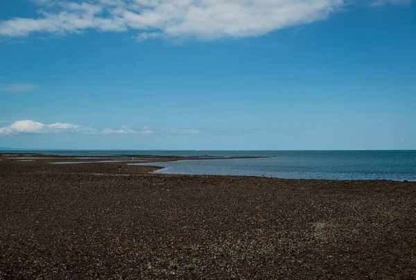 Tiro horizontal de uma bela maré baixa em um estuário de rio abaixo do céu nublado — Fotografia de Stock