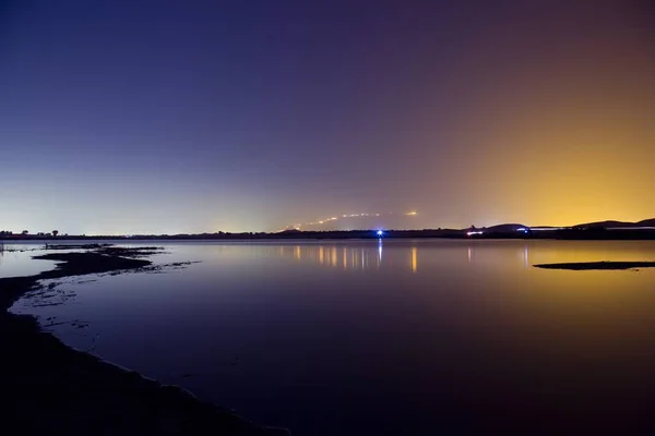 Krásné obrovské prázdné jezero v noci s fialovou a modrou oblohou — Stock fotografie