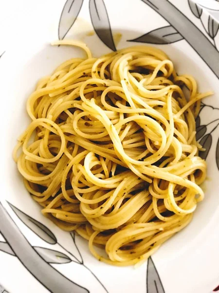 Senkrecht abgewinkelte Aufnahme köstlicher Pasta in einem weißen Teller, bereit für das Abendessen — Stockfoto