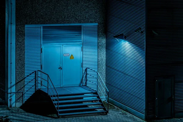 Vue horizontale d'une porte avec un panneau d'avertissement près des escaliers métalliques recouverts de lanterne lumineuse — Photo